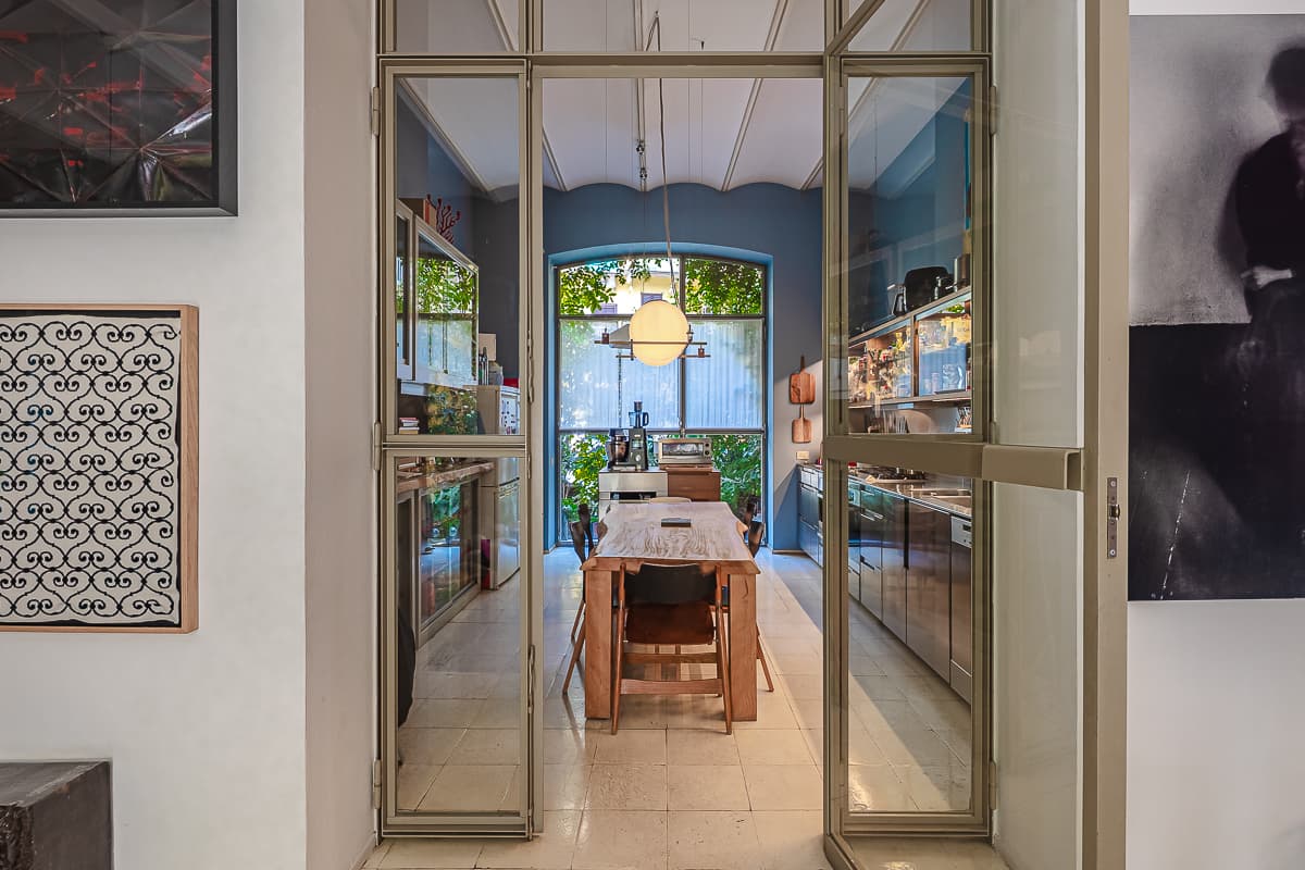 Una porta a vetri che si apre sul giardino interno di un loft